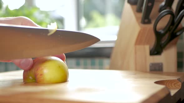 Slow motion of an apple being cut up into bite-sized pieces.