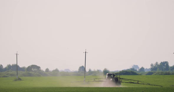 Tractor With Fertilizer Spreader Spraying Pesticides Or Chemicals On Field With Sprayer At Spring