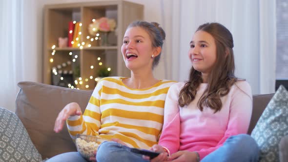 Teenage Girls Eating Popcorn Watching Tv at Home