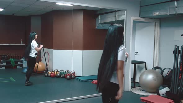 Young Beautiful Girl in a Gym Doing Situps with an Attack Forward