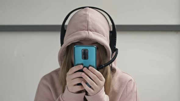 Teenager Looks at the Smartphone Screen Without Looking Up