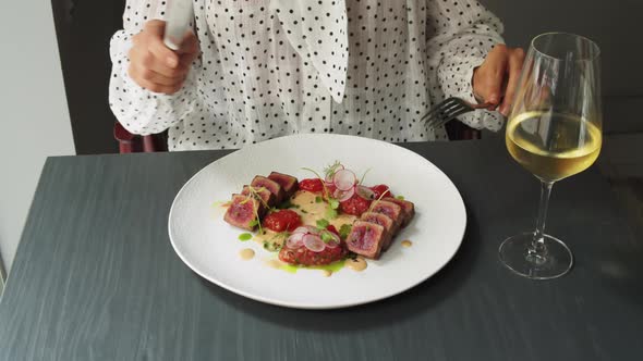 Elegant Woman Eating Tuna Steak with Colorful Salad in High Kitchen Restaurant Haute Cuisine Fine