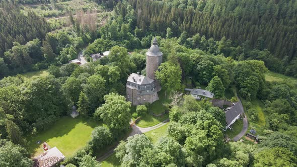 backwards drone shot of Wildenburg Castle in the southeast of the village of Friesenhagen , in the N