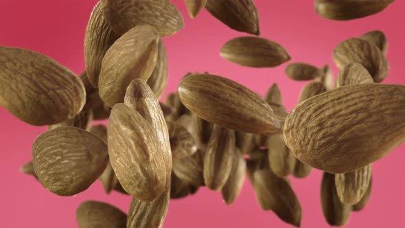 Flying of Almonds in Light Fuchsia Background