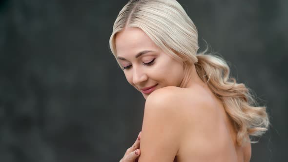 Adorable Smiling Young Woman Stroking Soft Naked Body Skin Posing at Black Studio Background