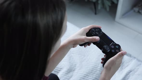 Girl playing video games with wireless controller