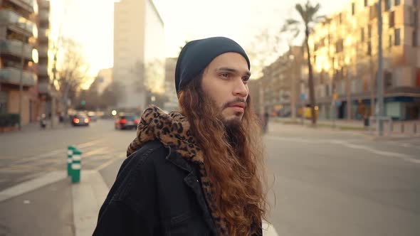 Portrait of Long Haired Hipster Walking on Street in Modern City