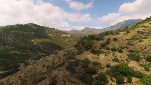 Drone footage of mountain ranges, forest and horizon.