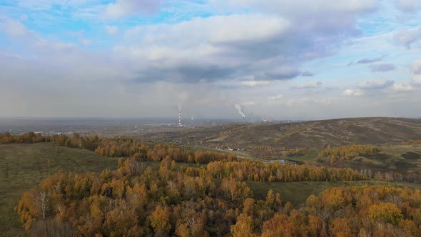 Aerial View of Factory in the City Surrounded By Beautiful Nature. Pipes with Chemical Smoke of