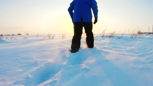 Feet of Hiker Walking in Deep Snow