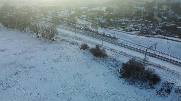 Flight over the city block. Winter cityscape. There is a railway line nearby.