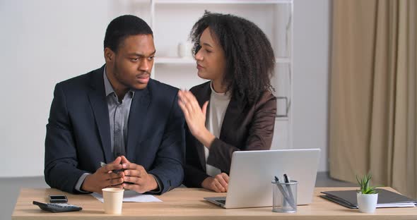 Afro American Businesspersons Colleagues Sitting in Office Evil Woman Whispers in Male Ear Secret