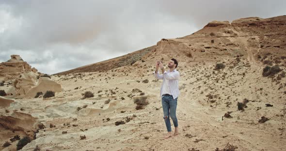 Young Tourist Man Walking Through the Rocks and