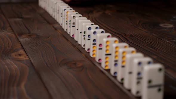 Closeup of a Line of Falling Dominoes on a Wooden Surface