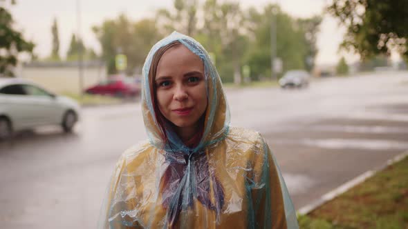 Delighted Young Woman Smiling at Camera on Rainy Day