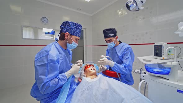Dentist with Assistant Treating Patients Teeth