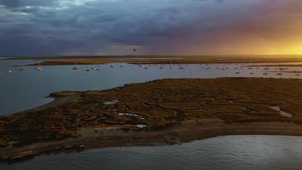 An aerial flight over the salt marshes at West Mersea, Essex just before a storm with dramatic light