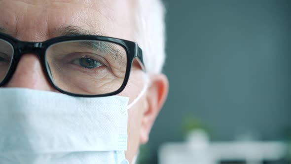 Close-up Portrait of Senior Man in Glasses Doctor Wearing Mask Indoors in Clinic