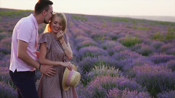 Young Couple Kisses in Flowering Lavender Field