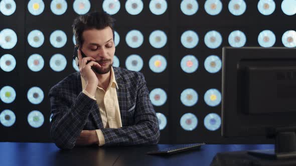 Businessman Dressed in Stylish Checkered Suit Speaks on Smartphone in Office