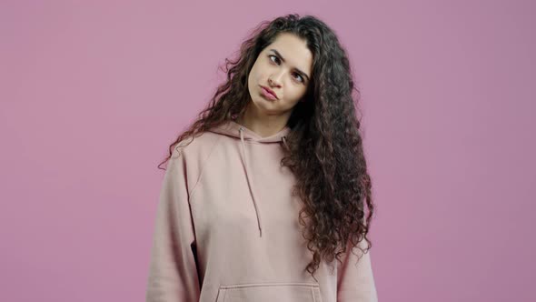 Portrait of Funny Young Woman Making Faces Then Sending Air Kiss on Pink Background