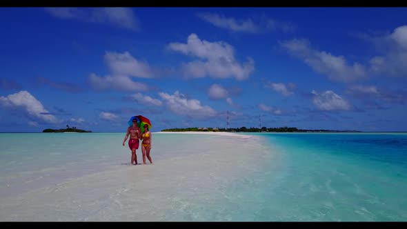 Two people happy together on paradise tourist beach journey by aqua blue sea and white sandy backgro
