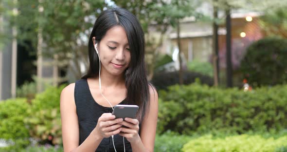 Woman listen to music on cellphone with earphone