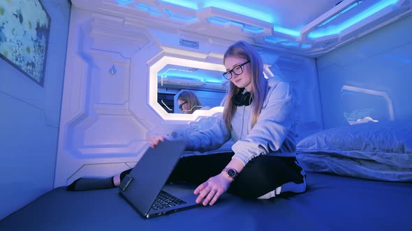 Young Girl Closes the Door of a Unit in a Capsule Hotel