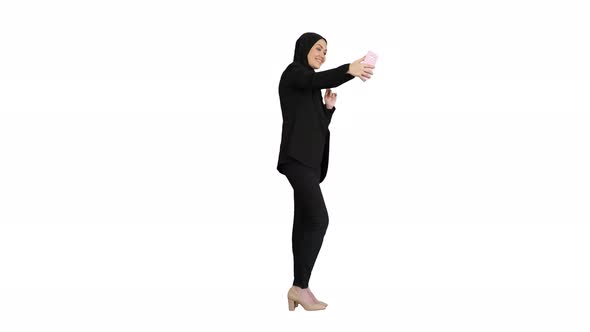 Smiling Arab Woman in Hijab Taking Selfie Pictures on Her Mobile Phone on White Background.