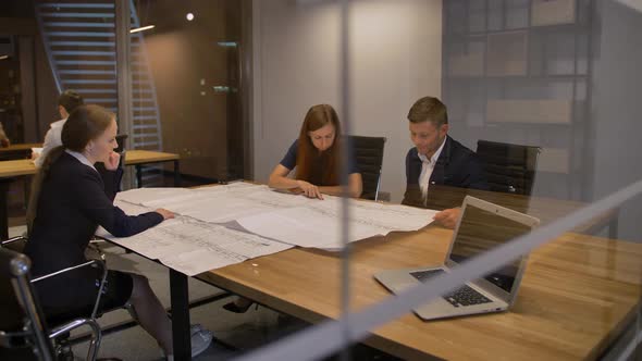 Businesspeople Work with Engineer Drawing at Office