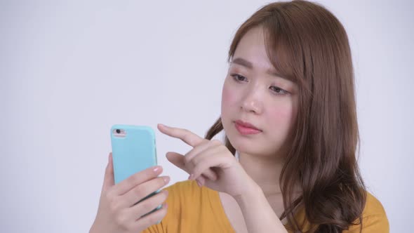 Face of Happy Young Beautiful Asian Woman Using Phone