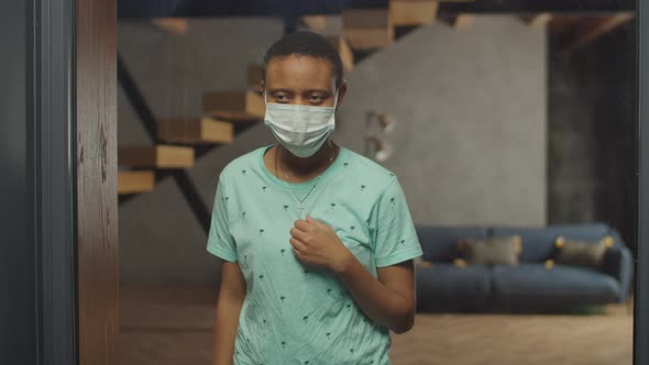 Unwell Woman in Medical Mask Looking Out Window