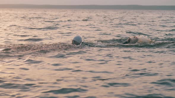 Professional Swimmer Is Swimming in the Sunset Ocean