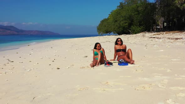 Girls happy together on tropical island beach holiday by blue water with white sand background of Lo
