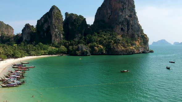 Aerial take off over long tail boats with limestone karst rocks in background. Railay Beach, Ao Nang