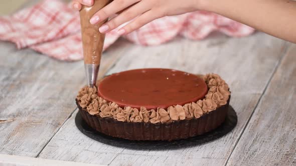 Confectioner Decorates Delicious Chocolate Tart with Cherry Confit and Chocolate Cream.