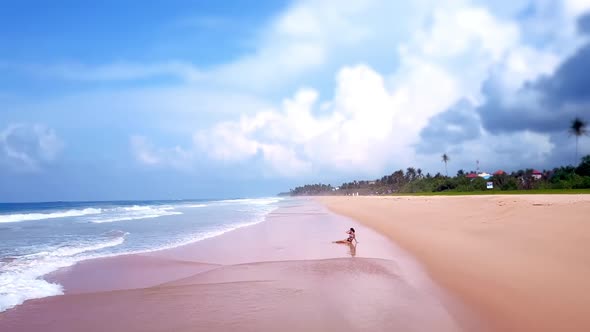 Focused Asian Woman Sitting on Sandy Beach Summer