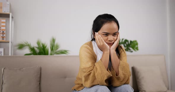 Girl headache while sitting on couch