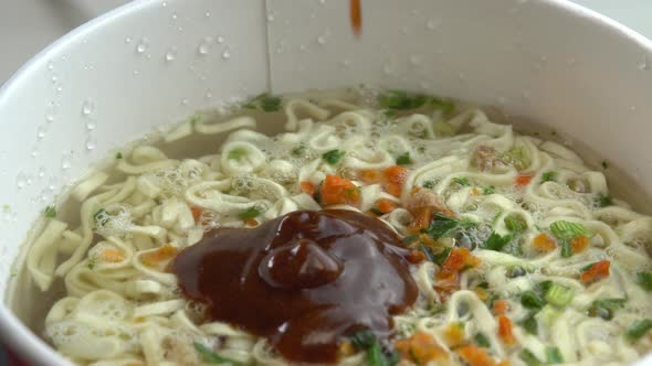 Adding Sauce to Instant Noodles Boiled Noodles with Sauce and Spices Rotate in the Package Asian