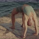 Blond Caucasian Yoga Teacher Practicing and Mastering Wheel Pose on a Cliff in Front of the Sea - VideoHive Item for Sale