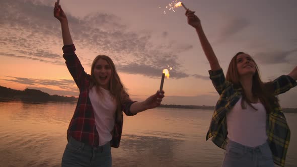 Beautiful Women in Summer with Sparklers Dancing in Slow Motion on the Beach at Night