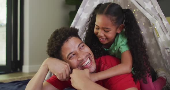 Happy biracial father and daughter embracing and smiling