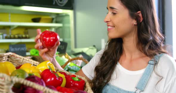 Woman selecting bell peppers in organic section