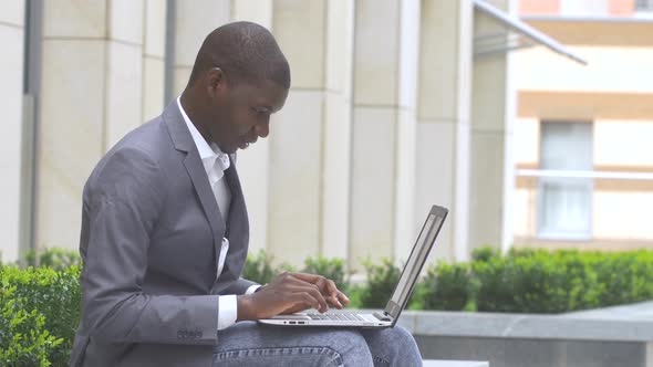 Happy African American Guy Displaying Computer Laptop on Outdoors