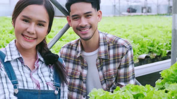 handheld asian couple farmer takecare and discuss how to growth plant in hydroponic farm