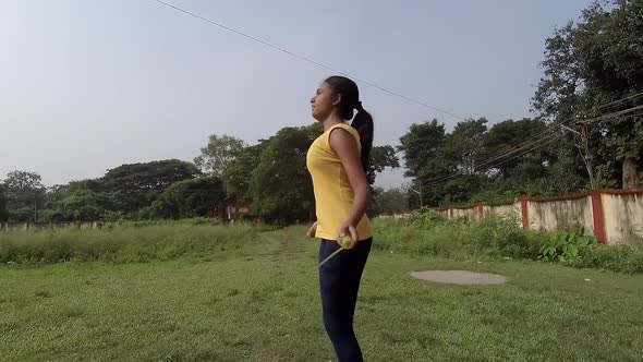 Teenage young Asian girl practicing skipping rope at playground at morning, Slow motion