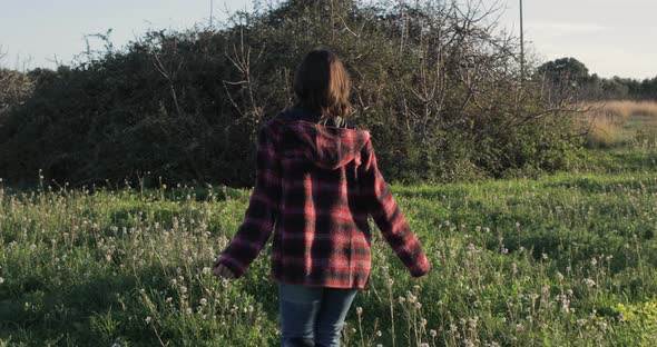 Girl walks in green field