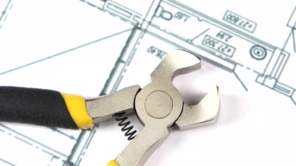 Wire Cutters with Yellow, Gray Handle on Building Plan, Scheme, Rotation, Close Up