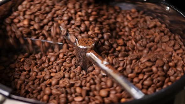 Freshly roasted coffee beans are spinning in coffee machine.