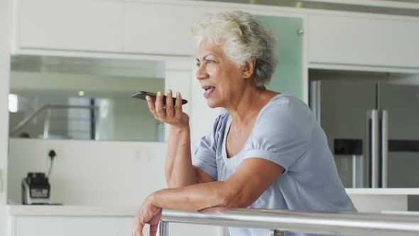 African american senior woman talking on smartphone at home